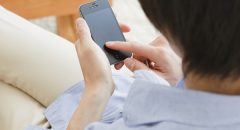 スマートフォンを操作する男性の後ろ姿